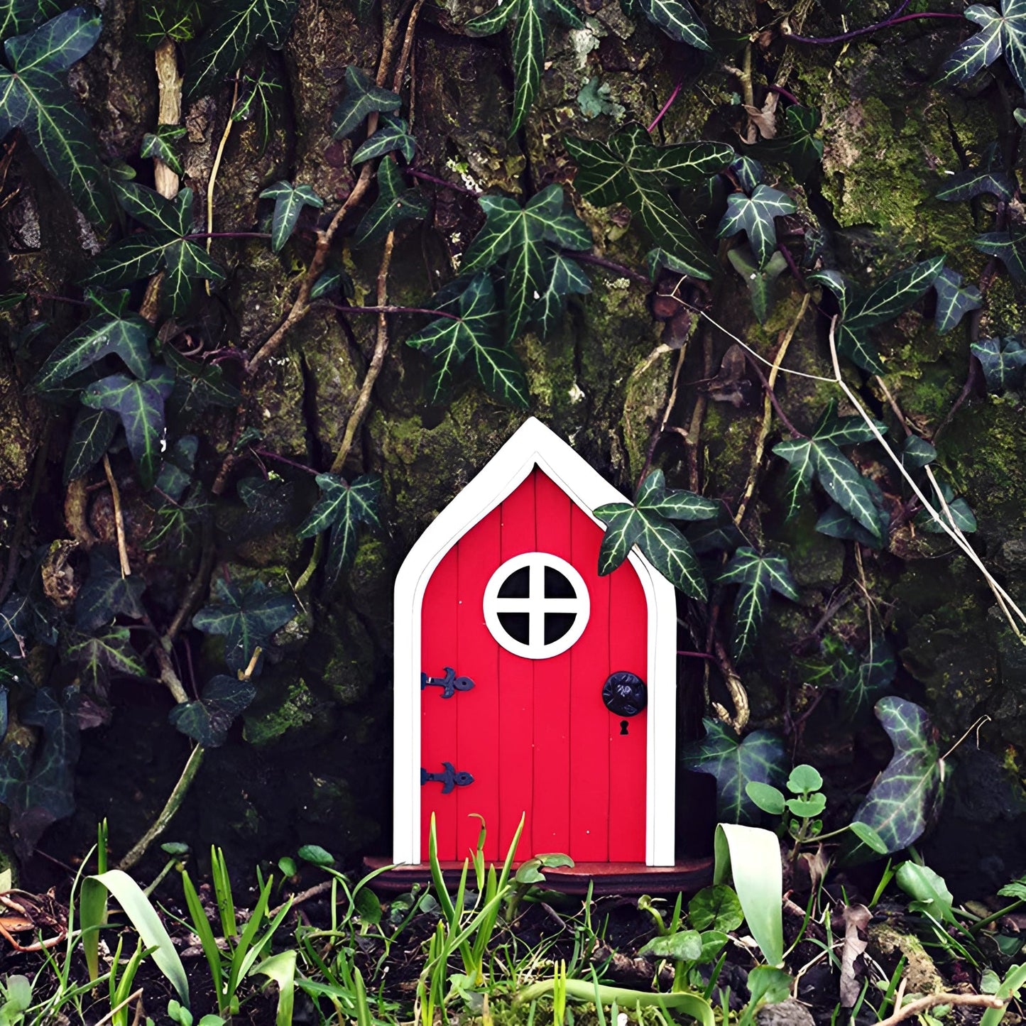 Miniature fairy garden door set within an enchanted tree, surrounded by lush greenery and natural elements, creating a whimsical woodland scene.