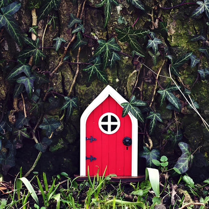Miniature fairy garden door set within an enchanted tree, surrounded by lush greenery and natural elements, creating a whimsical woodland scene.